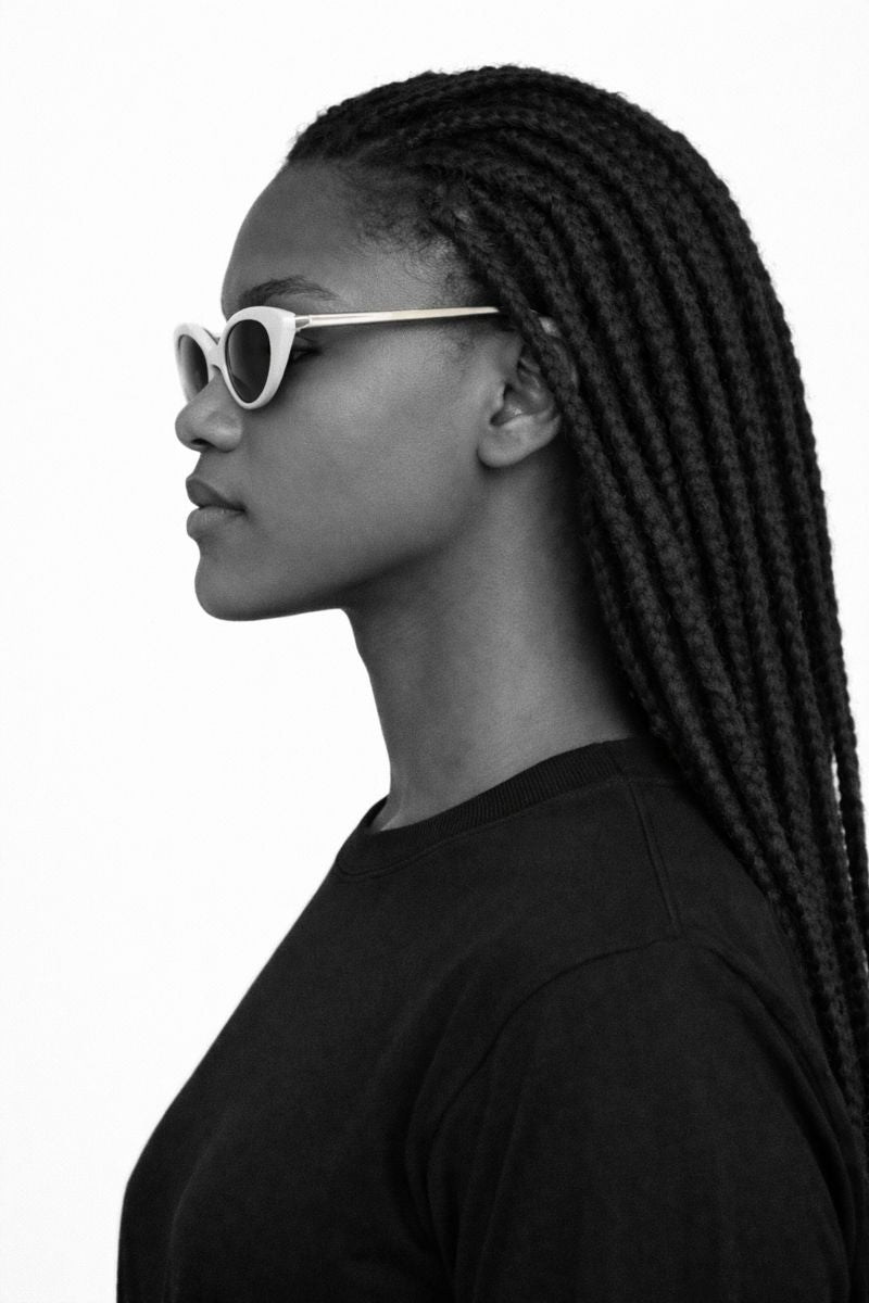Black and white profile of a person wearing sunglasses with braided hair.