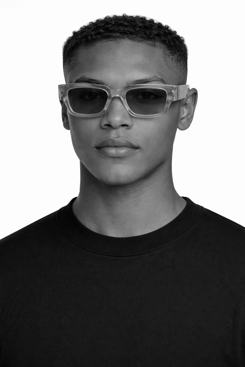Person wearing sunglasses and a black shirt in a black and white photo