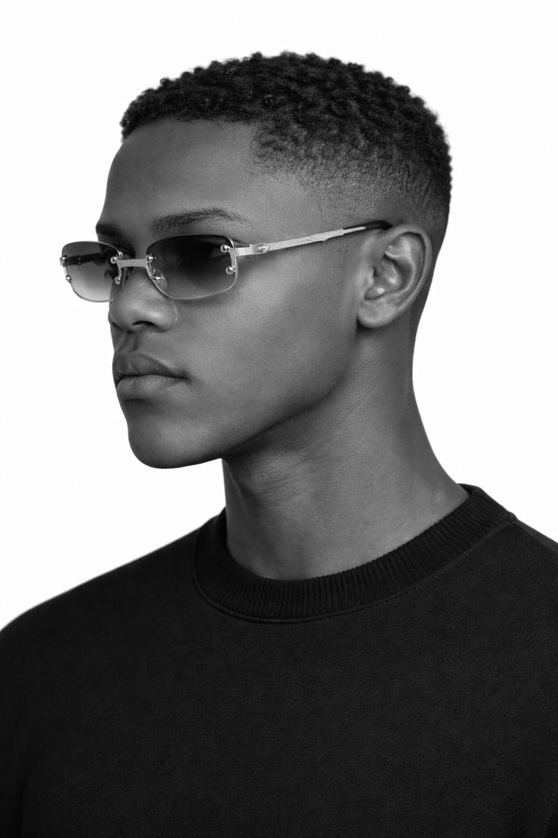 Person wearing sunglasses and a black shirt on a white background
