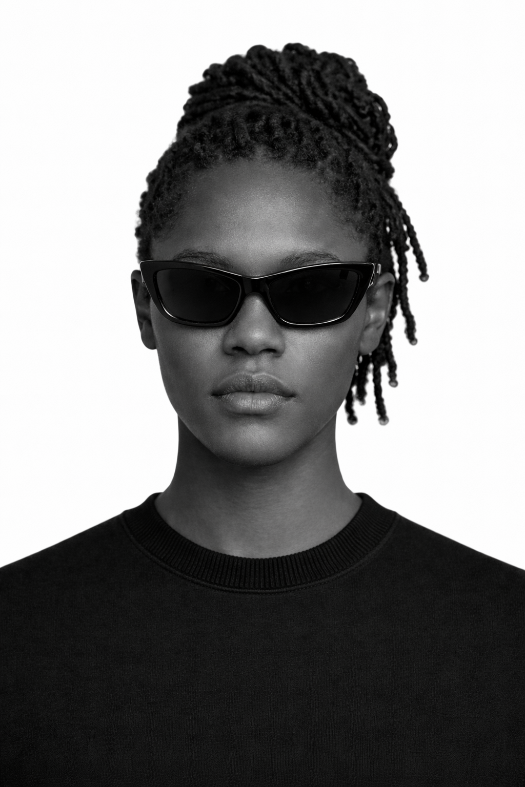 Person wearing sunglasses and a black sweater on a white background