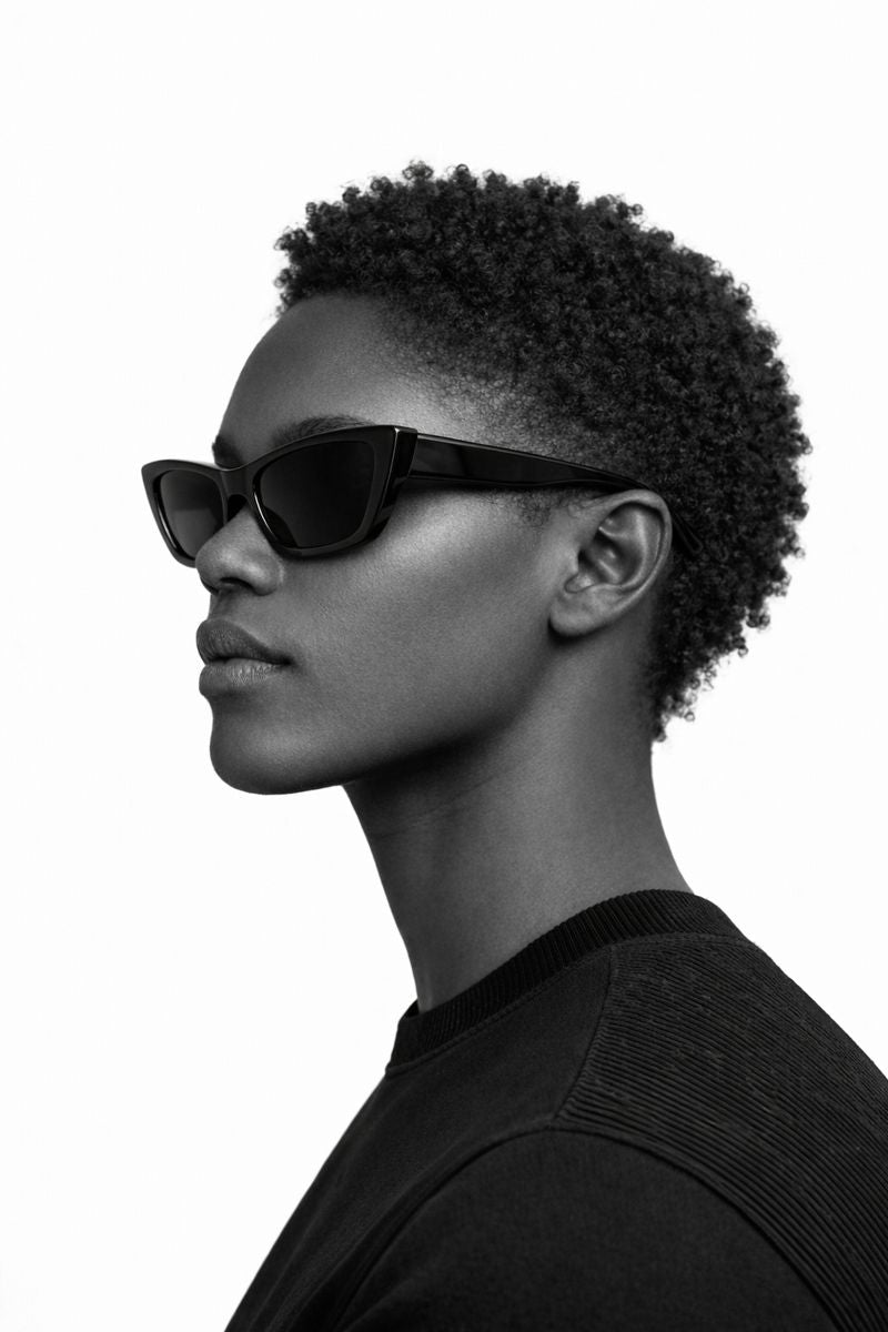 Black and white profile of a person wearing sunglasses with a plain background