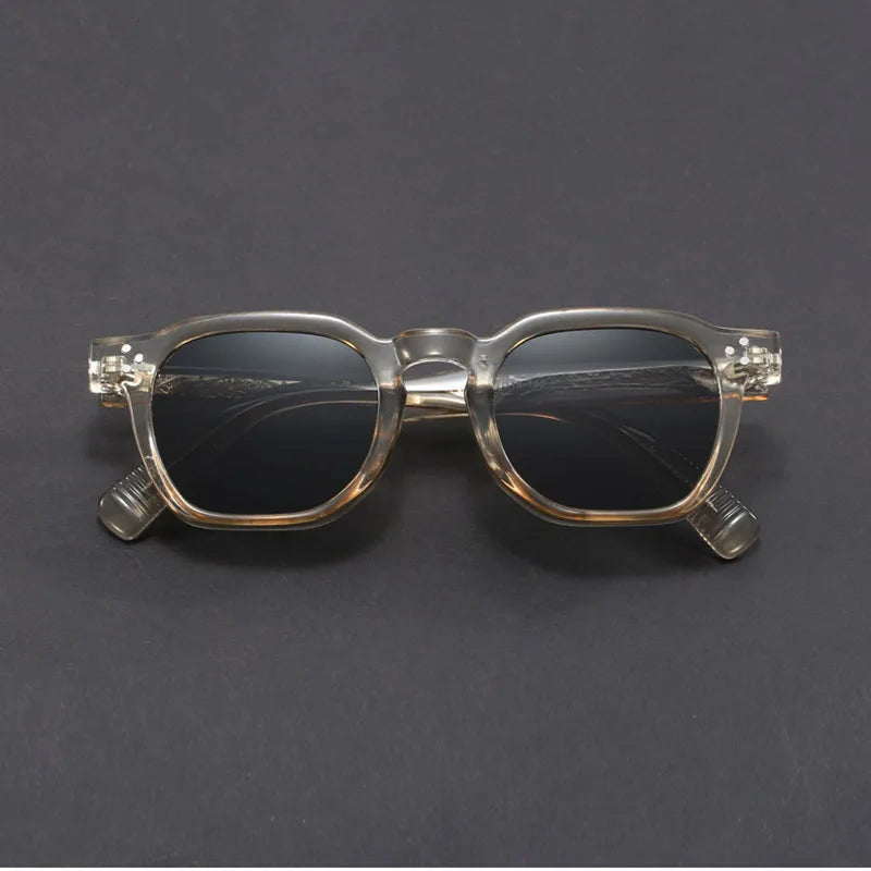 Clear sunglasses with dark lenses on a gray background