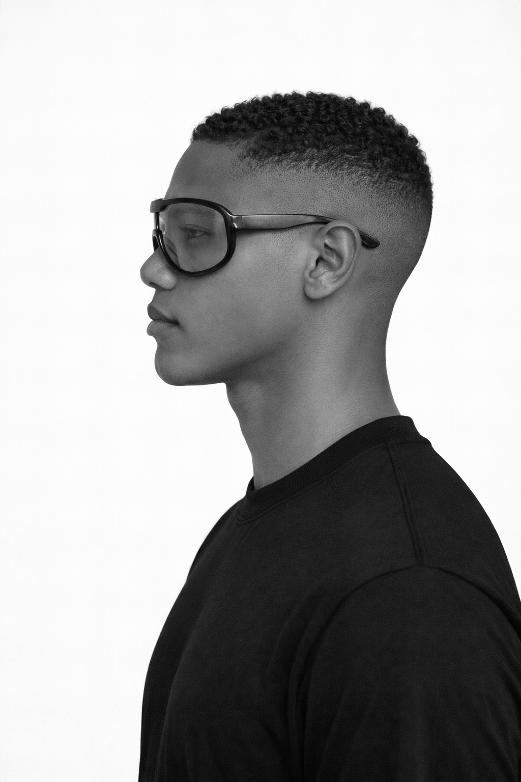 Black and white profile of a person wearing glasses and a black shirt.