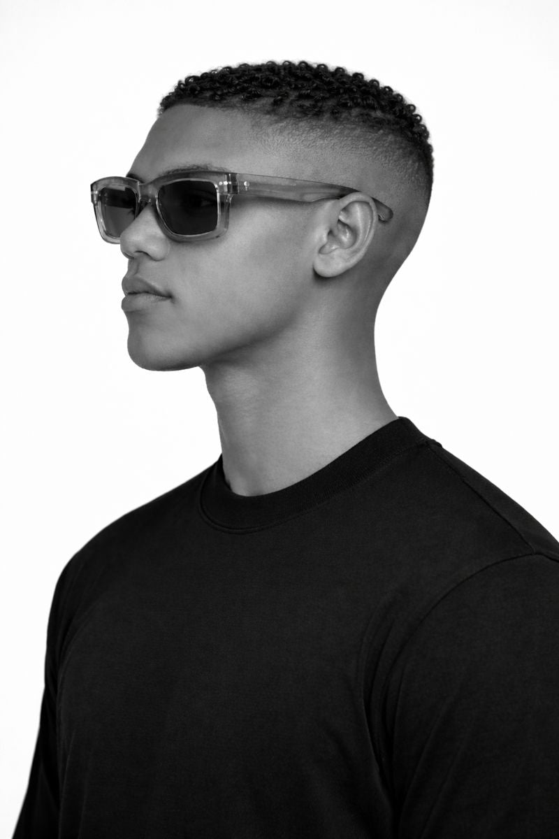 Black and white profile of a person wearing sunglasses and a black shirt.